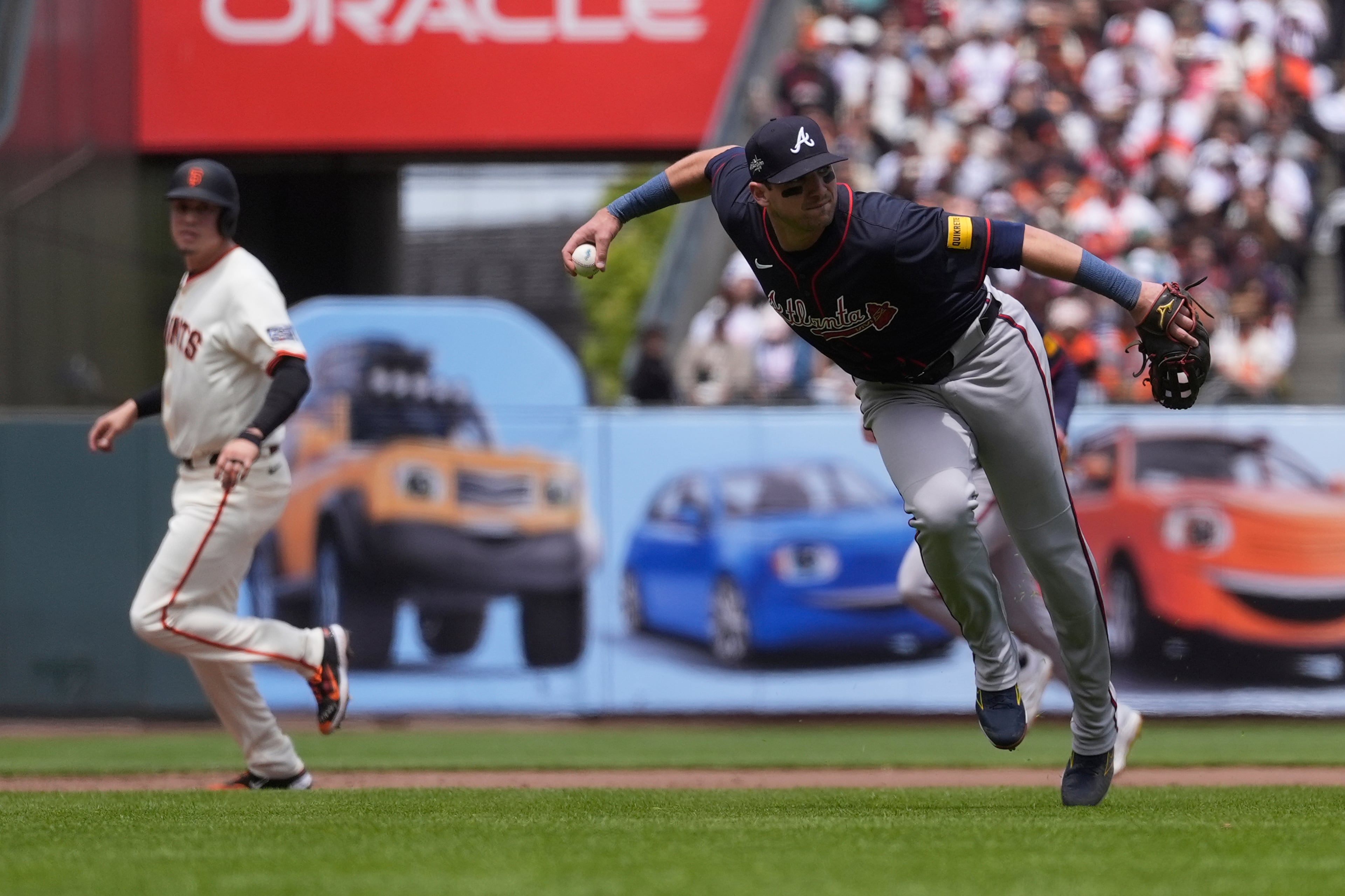 Atlanta Braves third baseman Austin Riley, right, fields a ground out hit into by San Francisco Giants' Casey Schmitt during the fourth inning of a baseball game in San Francisco, Sunday, June 8, 2025. (AP Photo/Jeff Chiu)