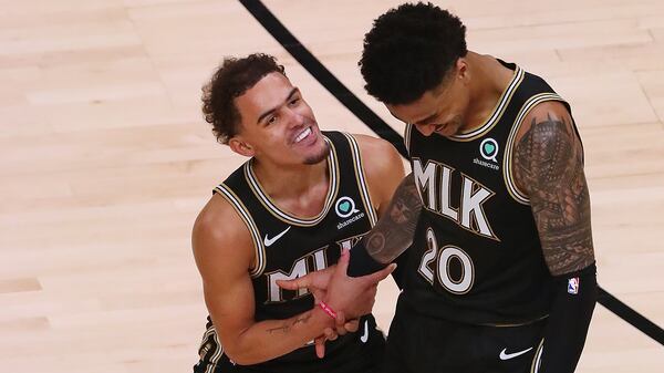 Hawks guard Trae Young celebrates with forward John Collins after he hit a three-pointer adding to Atlanta's second-half lead against the New York Knicks during Game 4 of their first-round NBA playoff matchup Sunday, May 30, 2021, at State Farm Arena in Atlanta. The Hawks beat the Knicks 113-96. (Curtis Compton / Curtis.Compton@ajc.com)