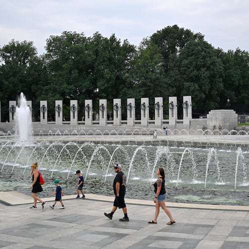 Visitors walk the WWII memorial the morning after it was vandalized, shown Friday, Aug. 14, 2026, in Washington. (AP Photo/John McDonnell)