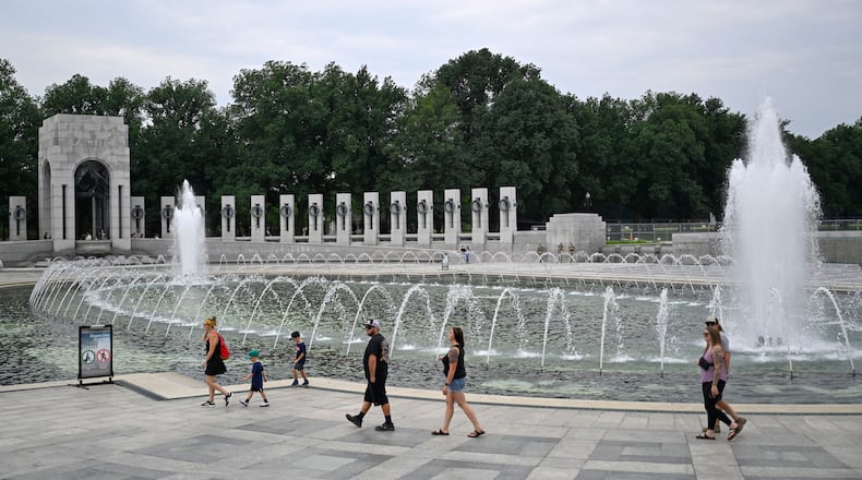Visitors walk the WWII memorial the morning after it was vandalized, shown Friday, Aug. 14, 2026, in Washington. (AP Photo/John McDonnell)