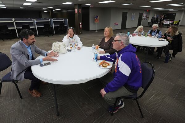 Ryan Kelley, left, talks with attendees before speaking at the Jackson County Republican headquarters, Thursday, April 10, 2025, in Jackson, Mich. (AP Photo/Paul Sancya)