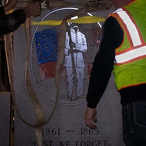 A crew works to remove a Confederate monument from its place on the grounds of the Gwinnett Historic Courthouse in Lawrenceville, Ga., on Thursday, Feb. 4, 2021. (Casey Sykes for the AJC)