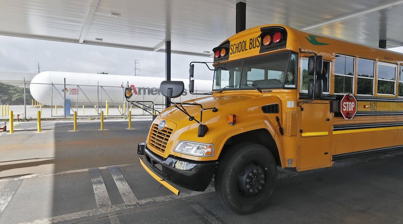 A Fulton County school bus pulls into the propane filling station at the school district bus yard in Alpharetta. The propane tank is in the background. Fulton has been replacing old diesel school buses with new ones powered by propane.