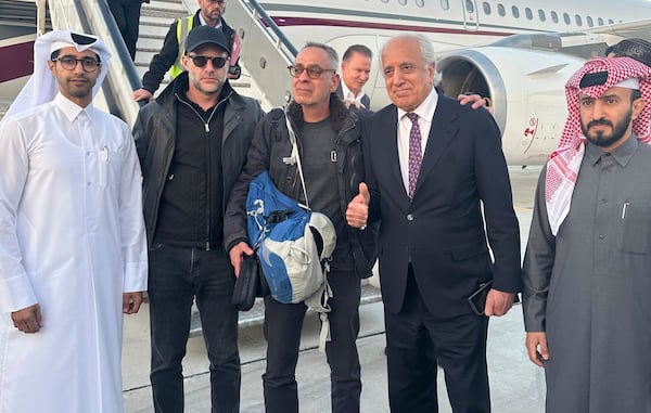 In this handout photo, George Glezmann (center) poses with Adam Boehler (second left) and Zalmay Khalilzad (second right) in Kabul, Afghanistan, on March 20 before departing to Doha. (Qatar Ministry of Foreign Affairs via AP)