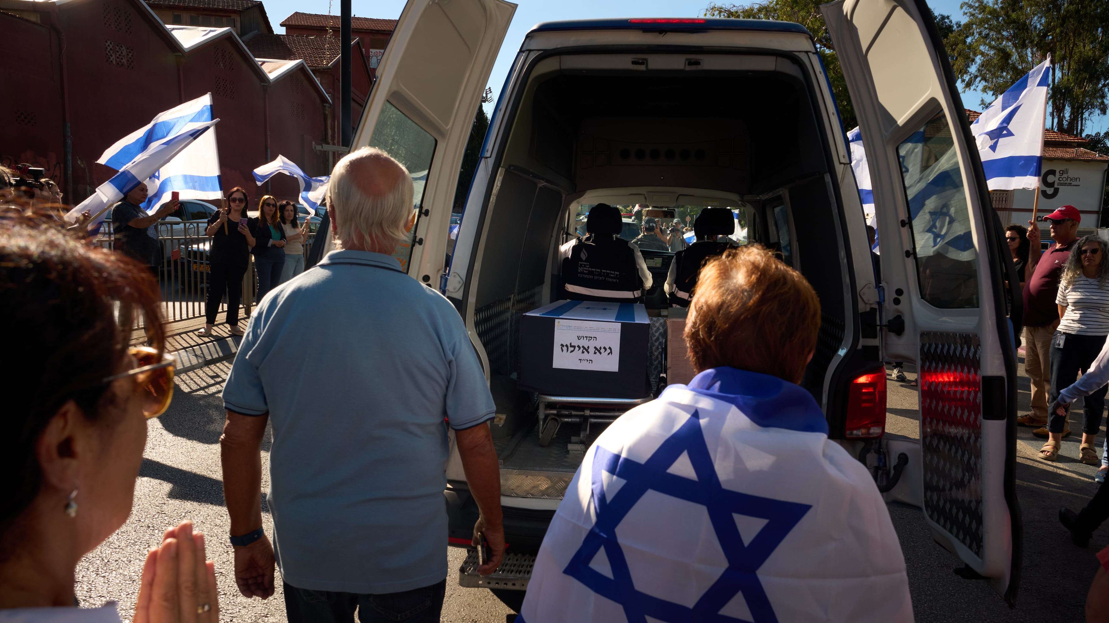 Mourners walk near the car carrying the coffin of slain hostage Guy Illouz during his funeral procession in Rishon Lezion, Israel, Wednesday, Oct. 15, 2025. Illouz remains were returned from Gaza to Israel as part of a ceasefire agreement between Israel and Hamas. (AP Photo/Emilio Morenatti)