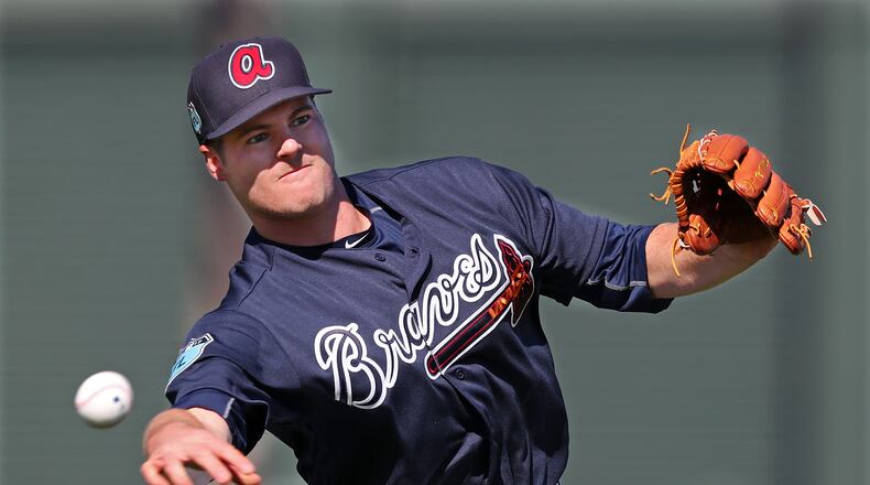 Braves pitcher Jason Hursh throws to first after fielding a grounder during spring training at the ESPN Wide World of Sports in Lake Buena Vista. Curtis Compton/ccompton@ajc.com