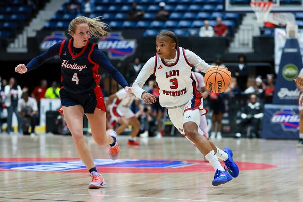 Sandy Creek guard Morghan Reckley (3) drives against Heritage-Catoosa forward Ema Tanner (4) during the first half in the Class 3A Girls GHSA State Championship at the Macon Coliseum, Wednesday, March, 11, 2026, in Macon, Ga. (Jason Getz/AJC)