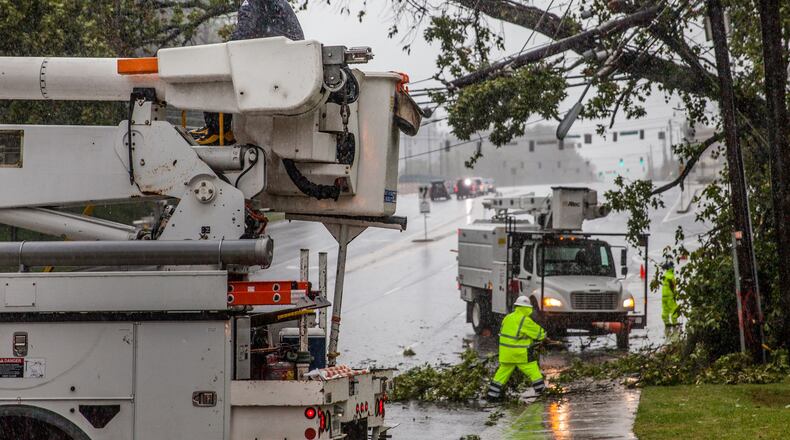 Crews work to clear a tree that fell on power lines on Hammond Drive, Monday, Sept. 11, 2017, in Sandy Springs, Ga. BRANDEN CAMP/SPECIAL