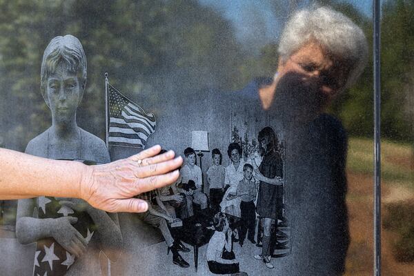 Margo Truett touches an image of her family engraved at the Dignity Memorial Vietnam Wall at the National Infantry Museum in Columbus.