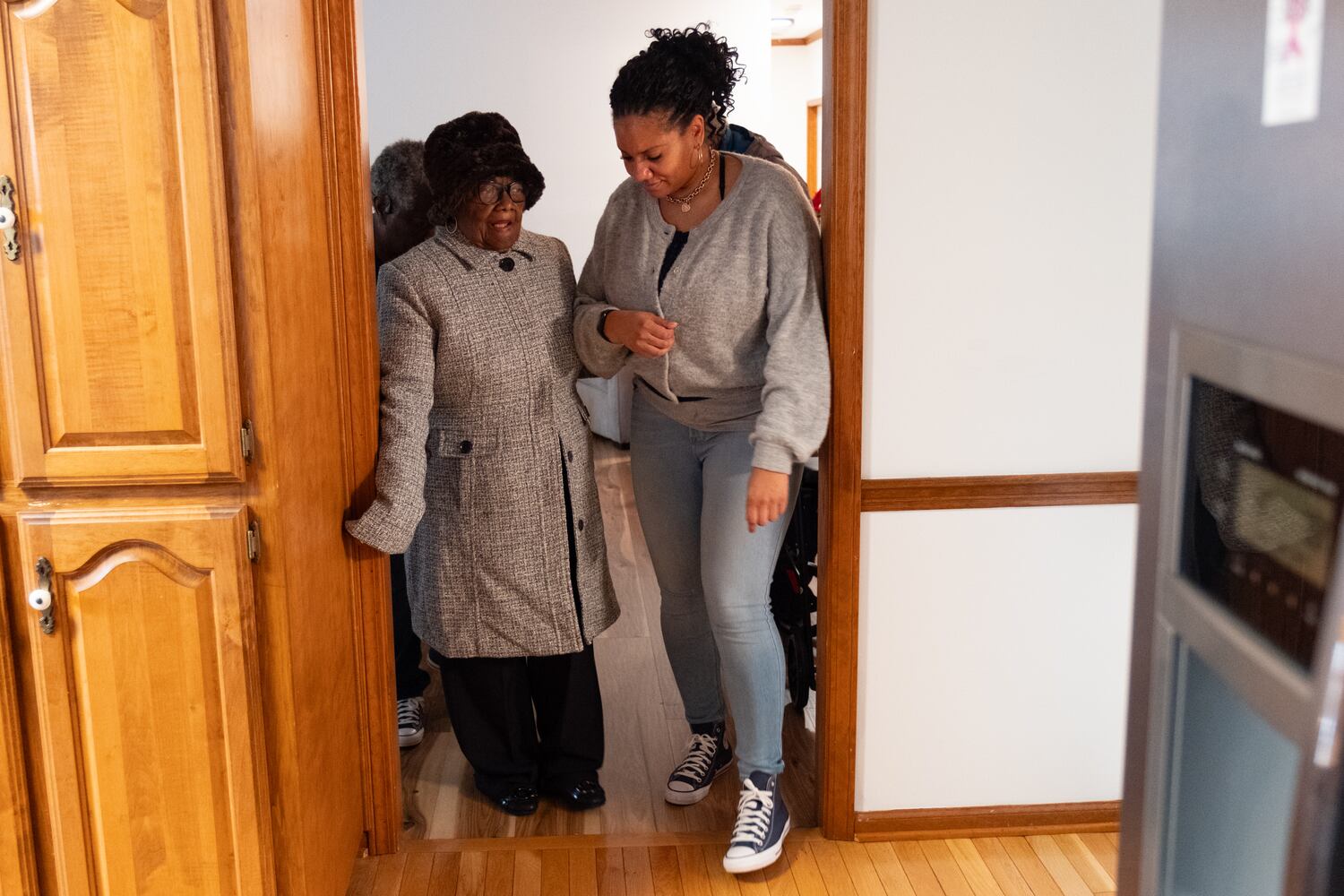 Lillie Mae Hightower gets a little help from her granddaughter Karla Mitchell as the pair heads outside to see a parade of DeKalb and Henry County Sheriff vehicles in celebration of her 102nd birthday in Stockbridge on Friday, Dec. 27, 2024.   Ben Gray for the Atlanta Journal-Constitution