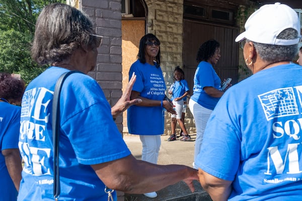 Sylvia Gibson Dunlap, center, talks with former residents of the "One Square Mile" community and their relatives gather on Wednesday, July 9, 2025, at the former Price’s Barbershop in College Park. The group, known as PHOAA, plans to create a museum for the community there starting this summer. Harvard Avenue, where the building sits, was once a thriving main street for the African American community before residents were pushed out due to increasing airport noise. (Ben Gray for The Atlanta Journal-Constitution)  