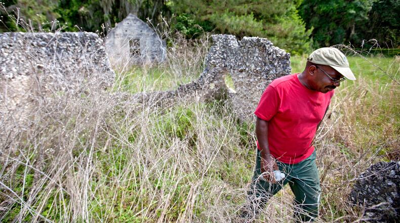 FILE - Ire Gene Grovner walks through remnants of the old slave's quarters at the Chocolate Plantation where his ancestors lived some eight generations ago on Sapelo Island, Ga., on May 16, 2013. (AP Photo/David Goldman, File)