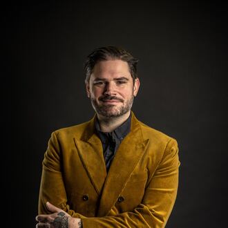 Jeff Banks, a professional Atlanta mixologist, is standing in a confident pose with a smile and crossed arms. He is the only bartender from the Southeast competing in the World Class Bartender competition finals this May.