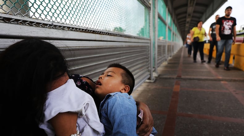A Honduran woman and her child wait along the border after being denied entry into Brownsville, Texas. More 2,300 immigrant children were separated from their parents as part of the Trump administration’s “zero-tolerance” border policy before President Donald Trump signed an executive order to keep immigrant families together in detention. (Photo by Spencer Platt/Getty Images)