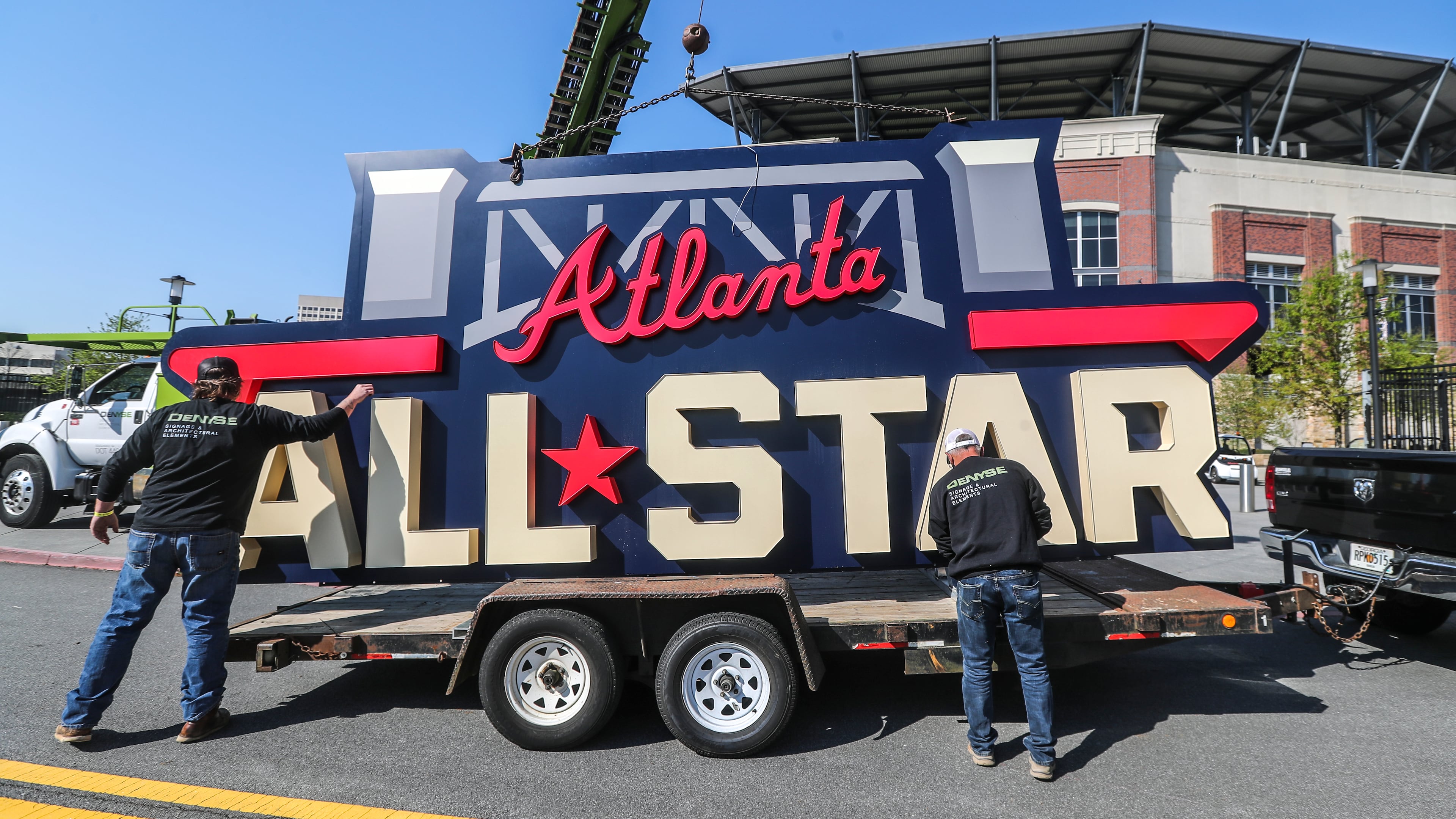 Workers with DeNYSE load the All-Star sign after removing it from near the stadium’s scoreboard on Tuesday, April 6, 2021, at Truist Park. (John Spink/AJC)