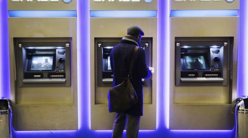 A customer uses an ATM at a branch of Chase Bank in New York. The ATM recently turned 50. (AP Photo/Mark Lennihan, File)