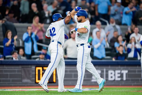 Toronto Blue Jays outfielder Anthony Santander (left) celebrates hitting a home run with first base Vladimir Guerrero Jr. against the Atlanta Braves during fifth inning MLB baseball action in Toronto on Tuesday, April 15, 2025 (Thomas Skrlj/The Canadian Press via AP)