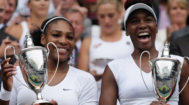 FILE -Serena Williams, left, and Venus Williams of the U.S hold their trophies after winning the women's doubles final against Yaroslava Shvedova of Kazahkstan and Timea Babos of Hungary on day thirteen of the Wimbledon Tennis Championships in London, July 9, 2016. (AP Photo/Tim Ireland, File)
