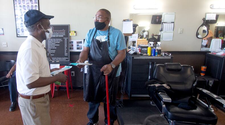 CEO Michael Thurmond talks with the Manager of Brown's The Barber Lounge John Phillips as Thurmond hands out masks and No Mask, No Service signs to businesses on Wesley Chapel Rd in Decatur, Saturday 25, 2020.  STEVE SCHAEFER FOR THE ATLANTA JOURNAL-CONSTITUTION