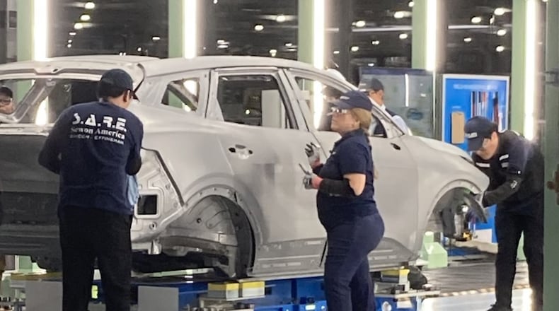Hyundai factory workers, known as metapros, inspect a Kia Sportage hybrid autobody during the manufacturing process on Tuesday, June 2, 2026, at the Hyundai Metaplant near Savannah, Georgia. (Adam Van Brimmer/AJC)