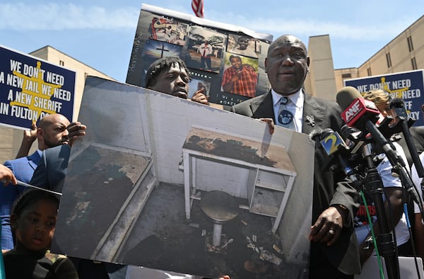 Attorney Ben Crump (right) and Brad McCrae (left), younger brother of Lashawn Thompson, hold a photograph to show the jail cell condition during a press conference outside the Fulton County Jail, Thursday, April 20, 2023, in Atlanta. Lashawn Thompson, 35, was discovered unresponsive in the jail’s psychiatric wing covered in bed bugs in September, according to a Fulton County Medical Examiner report. His body showed no obvious signs of trauma and the cause of death was undetermined, the report said, noting a “severe bed bug infestation” in the jail. (Hyosub Shin / Hyosub.Shin@ajc.com)
