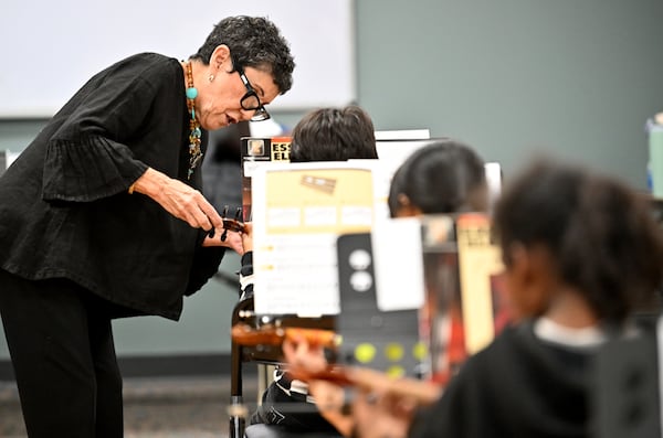 Juana Alzaga — known to her students as Miss Juanita — helps a member of the Buford Highway Orchestra Project with holding a violin bow the proper way at the Latin American Association on Thursday, Nov. 6, 2025, in Brookhaven. (Hyosub Shin/AJC)