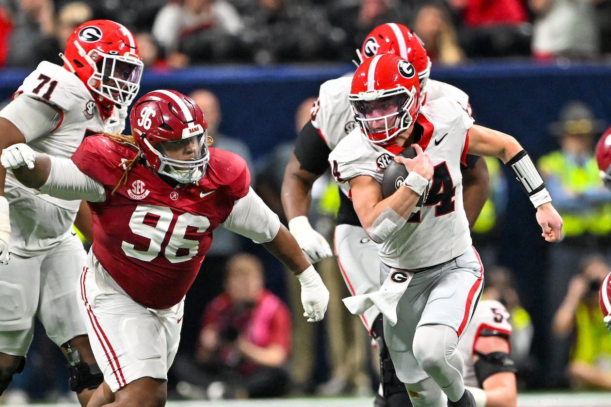 Georgia quarterback Gunner Stockton runs a keeper play against Alabama defensive lineman Tim Keenan III during the third quarter of the SEC championship game on Saturday. (Hyosub Shin/AJC)