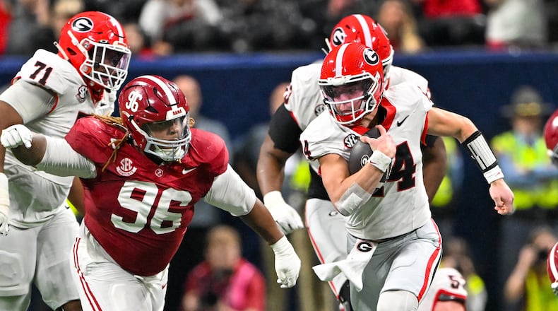 Georgia quarterback Gunner Stockton runs a keeper play against Alabama defensive lineman Tim Keenan III during the third quarter of the SEC championship game on Saturday. (Hyosub Shin/AJC)