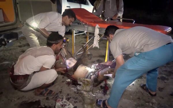 This photo taken from video released by Al Masirah TV channel shows medics carrying a severely wounded person onto a stretcher after U.S. airstrikes targeted the Ras Isa oil port held by Yemen's Houthi rebels in Hodeida, Yemen, Friday, April 18, 2025.( Al Masirah TV via AP)