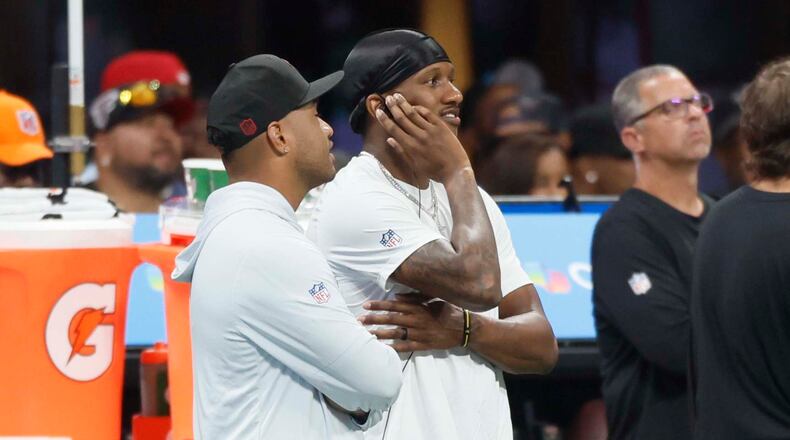 Atlanta Falcons quarterbacks Tua Tagovailoa (left) and Michael Penix Jr. watch from the sidelines Sunday. One of them might start Thursday night's game against the Green Bay Packers. (Miguel Martinez/AJC)