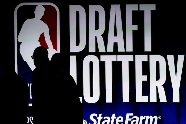 People walk by a sign during the 2023 NBA draft lottery.