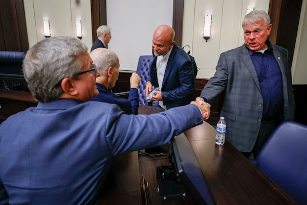 Tim Perry, managing director and chief investment officer at Jamestown, shakes hands with Alpharetta Mayor Jim Gilvin on Tuesday, Aug. 25, 2025, after the City Council votes 4-3 to rezone Jamestown’s mall redevelopment, which is vying to attract an NHL franchise. (Miguel Martinez/AJC)