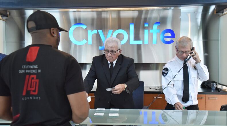 Gary Smith (center), 73, helps Darren Sligh (foreground), with checking-in as Doug Graham, security supervisor, answers a call at CryoLife, where Smith works as a security officer, in Kennesaw. Smith, 73, retired for two years but came back to work at 69, working for Allied Universal, the security company. Older workers are the fastest growing segment of the employed in Georgia and the U.S. (Hyosub Shin / Hyosub.Shin@ajc.com)