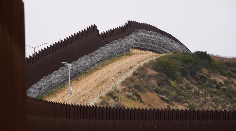 FILE - Concertina wire lines the interior of a border wall separating Tijuana, Mexico, from the United States, June 4, 2025, in San Diego. (AP Photo/Gregory Bull, File)