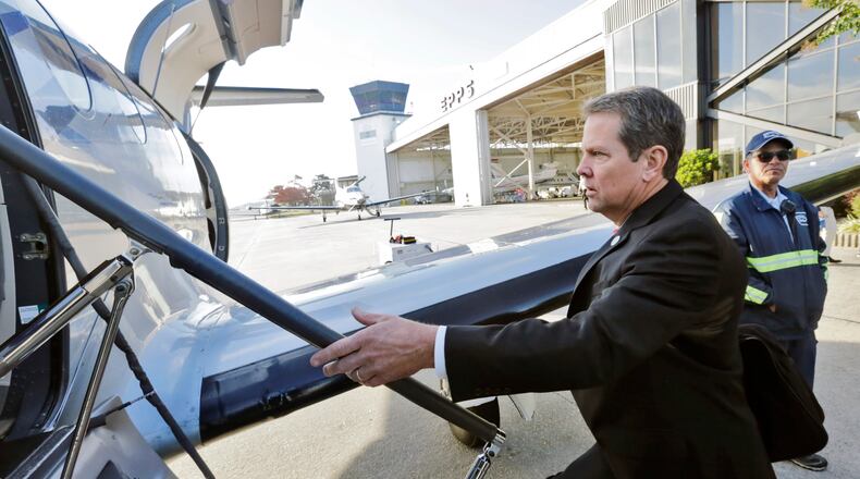 Georgia Secretary of State Brian Kemp boards a plane kicking off a statewide tour ahead of the 2016 election. BOB ANDRES /BANDRES@AJC.COM