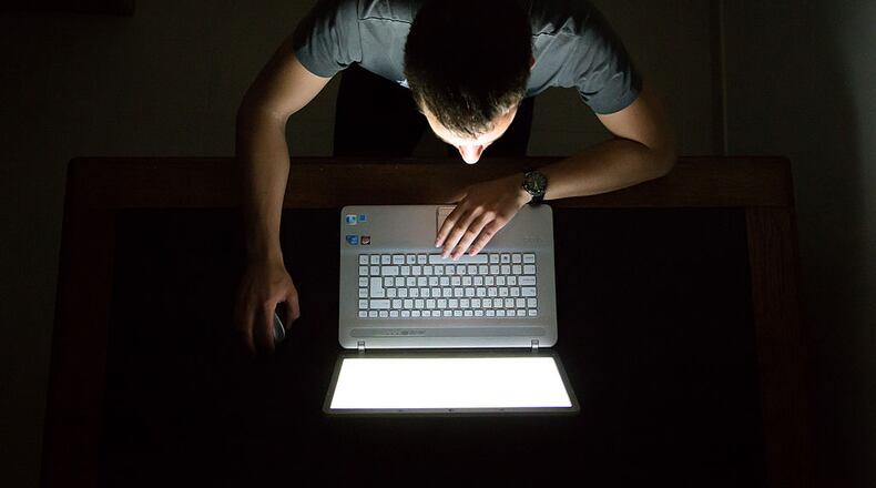 Guy checking internet with laptop at late night with dark room, view from above. Internet addiction.