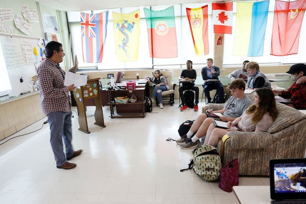 Students listen to an economics lesson at Tapestry Public Charter School in DeKalb County. Students sit informally and are allowed to get up and take breaks during class if needed. (Miguel Martinez/AJC)