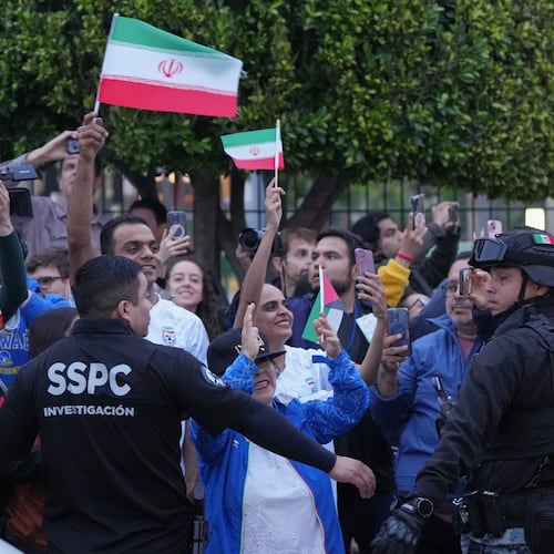 Fans for team Iran wave as players arrive for the World Cup soccer tournament in Tijuana, Mexico, Sunday, June 7, 2026. (AP Photo/Gregory Bull)