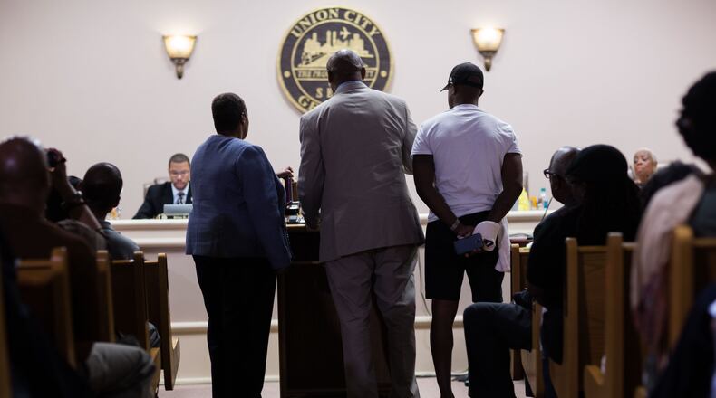 Freda Waiters, left, lawyer Mawuli Davis, center, and an unidentified man read statements during a council meeting at City Hall in Union City on Tuesday, May 19, 2015. Waiter and supporters gathered to address the Union City Council after a Union City Police officer killed Ariston Waiters in December 2011. BRANDEN CAMP/SPECIAL