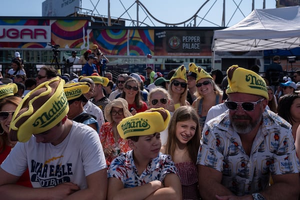 People wait for the 2025 Nathan's Famous Fourth of July hot dog eating contest in the Coney Island section of the Brooklyn borough of New York, Thursday, July 4, 2025. (AP Photo/Yuki Iwamura)