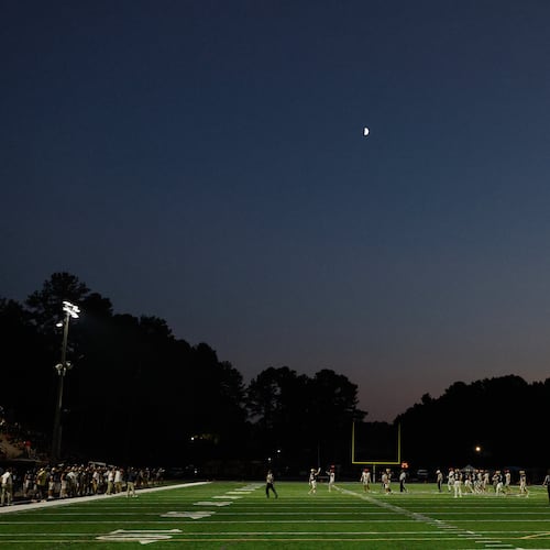 Teams play under a first quarter moon as Winder-Barrow faces off against St. Pius X on Friday, Sept. 18, 2026, in Atlanta. (Erik S. Lesser for the AJC)