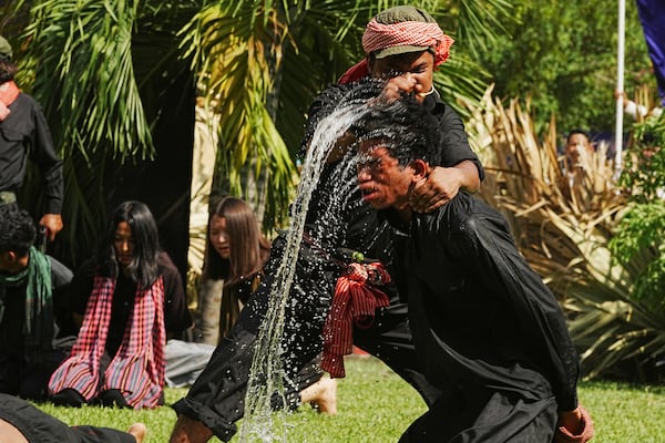 Cambodian students from Royal University of Fine Arts reenact a torture by immersing the head in water, by the Khmer Rouge during their reign of terror in the 1970s in an event hosted by the ruling Cambodian People's Party to mark the annual of Remembrance Day at Choeung Ek, a former Khmer Rouge "killing field," on the outskirt of Phnom Penh, Cambodia Tuesday, May 20, 2025. (AP Photo/Heng Sinith)