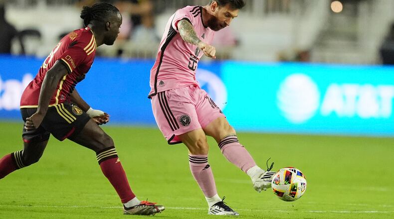 Inter Miami forward Lionel Messi (10) passes the ball as Atlanta United midfielder Tristan Muyumba (8) attempts to defend during the first half of their MLS playoff opening round soccer match, Saturday, Nov. 9, 2024, in Fort Lauderdale, Fla. (AP Photo/Rebecca Blackwell)