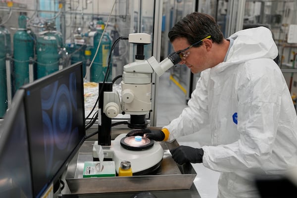 Taylor Duffin, of TRISO-X, a subsidiary of X-Energy, looks at a sample of TRISO fuel through a microscope Friday, June 27, 2025, in Oak Ridge, Tenn. (AP Photo/George Walker IV)