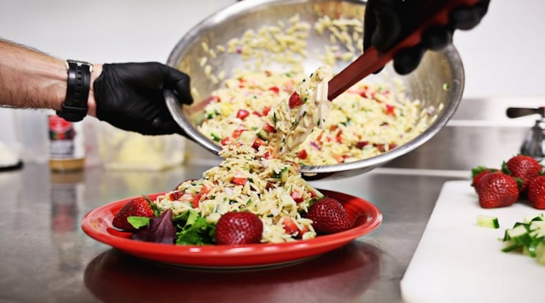 Adam Dillard of Berry Brothers makes his orzo pasta salad with the company's Strawberry Rosemary Vinaigrette May 11, 2018, in Raleigh.  (Juli Leonard/Raleigh News & Observer/TNS)