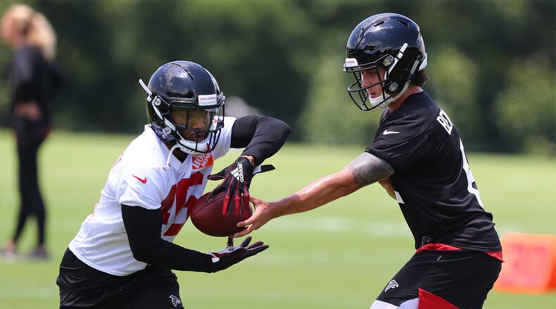 Quarterback Kurt Benkert hands off to running back Tony Brooks-James during on-field activities. (Curtis Compton/ccompton@ajc.com)