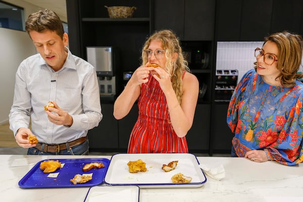 AJC Food & Dining Senior Editor Monti Carlo watches Lifestyle Reporter Olivia Wakim and Sr. Enterprise Reporter Thomas Lake sample fried chicken at a contest on Tuesday, Aug. 25, 2026, at the AJC office in Midtown. The event aims to find Atlanta’s top fried chicken. (Miguel Martinez/AJC)