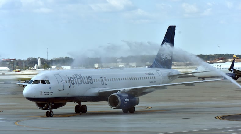 JetBlue Flight 519 gets a water cannon salute in Atlanta as it arrives from JFK. HYOSUB SHIN / HSHIN@AJC.COM