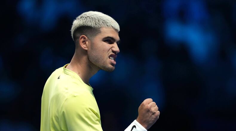 Spain's Carlos Alcaraz reacts after winning a point against Australia's Alex de Minaur during their singles tennis match of the ATP World Tour Finals, in Turin, Italy, Sunday, Nov. 9, 2025. (AP Photo/Antonio Calanni)