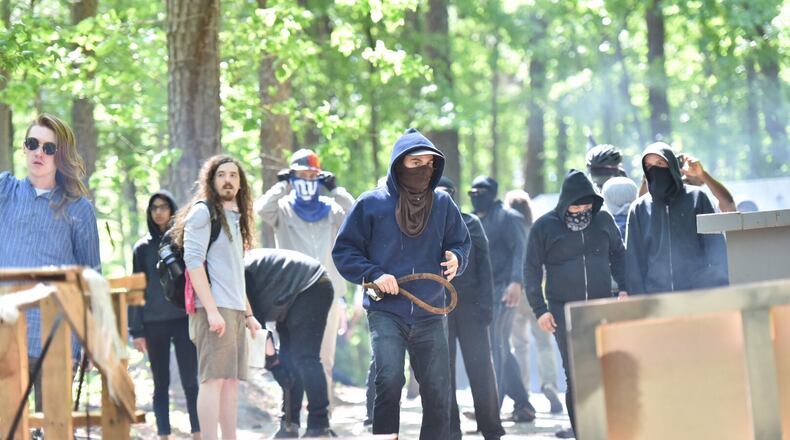 Counter-protesters set barricades and throw rocks and chairs at police during a clash at Stone Mountain Park on Saturday, April 23, 2016. Violent protests surrounding a white power rally at Stone Mountain have caused officials to shut down public attractions at the park. HYOSUB SHIN / HSHIN@AJC.COM
